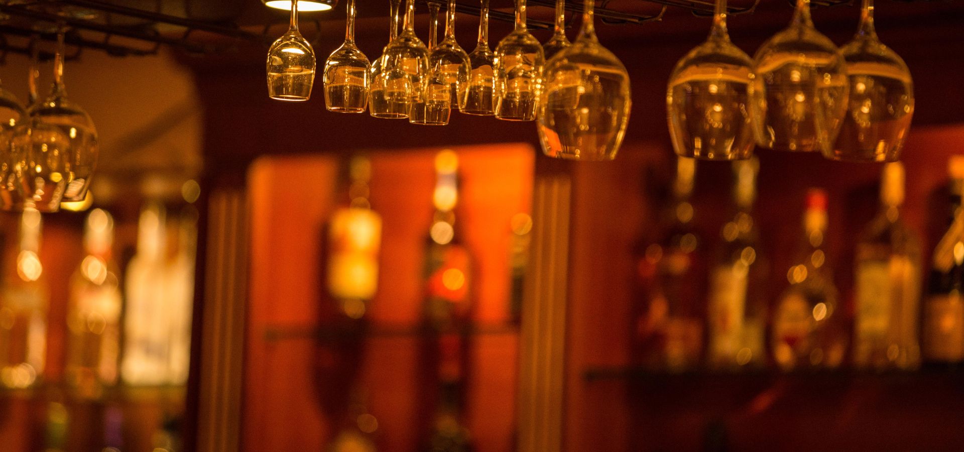 Barra de Rouge con copas colgadas y luz cálida